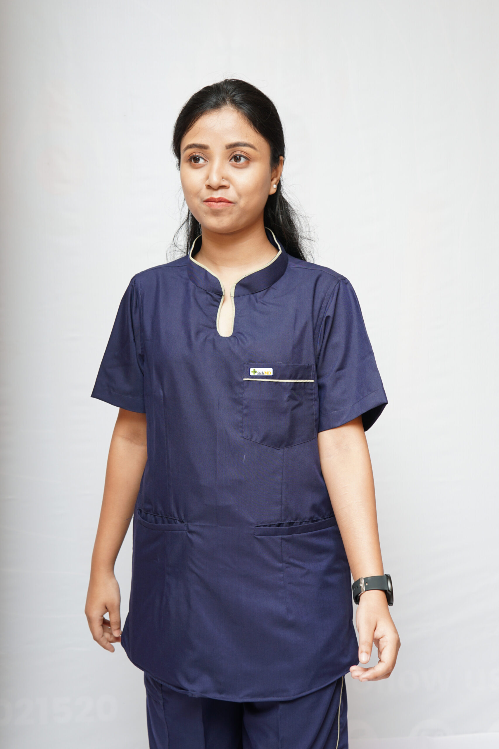 A woman wearing this scrub top with two bone pockets and one chest pocket, designed for doctors, nurses, and healthcare professionals.